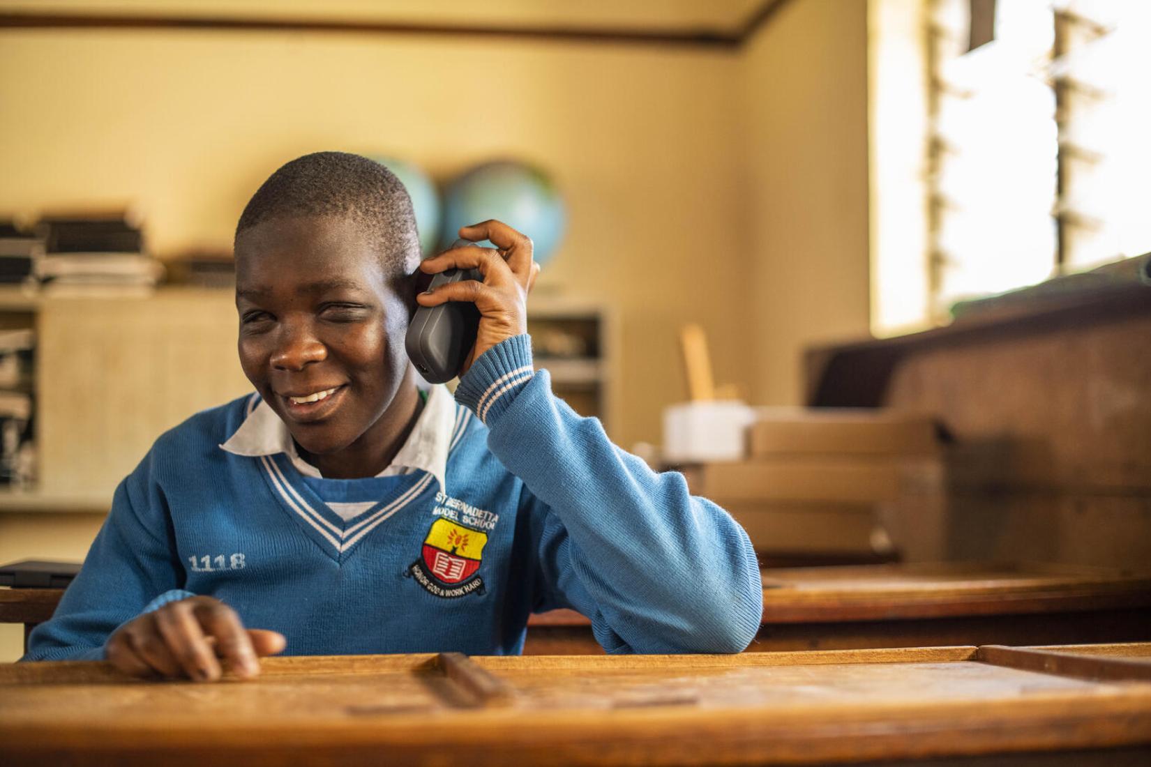Susan Atuhairwe (15) from St. Bernadette Primary school in Hoima listens to a recorded lesson from a Victor reader.